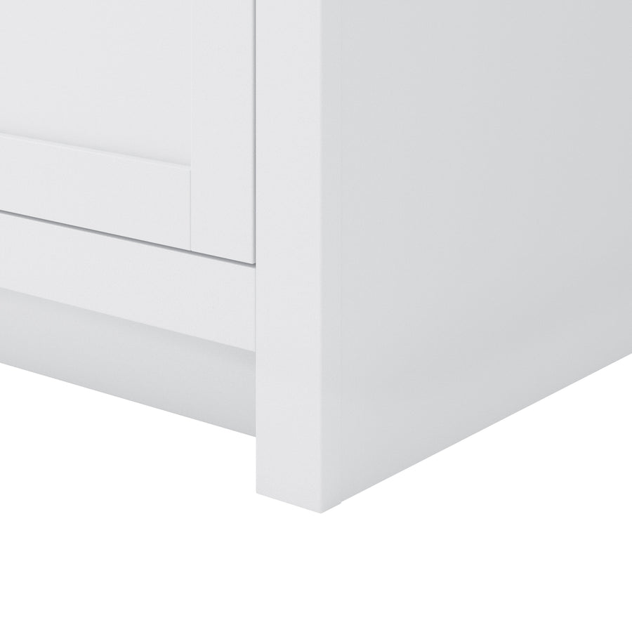 Close-up of the bottom corner of a white cabinet or dresser, showing clean lines and minimalistic design.