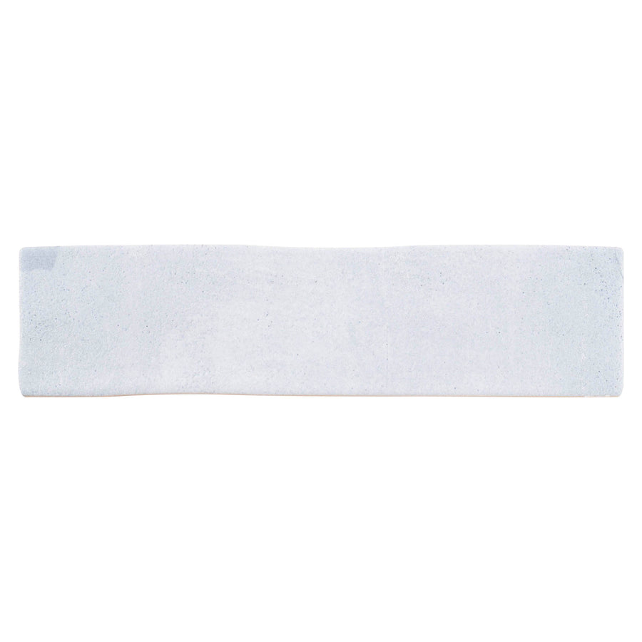 A rectangular blue subway tile, the Rhythmique 3" x 12" Ceramic Subway Tile features a smooth surface and modern design, making it ideal for contemporary interiors. Shown against a white background.