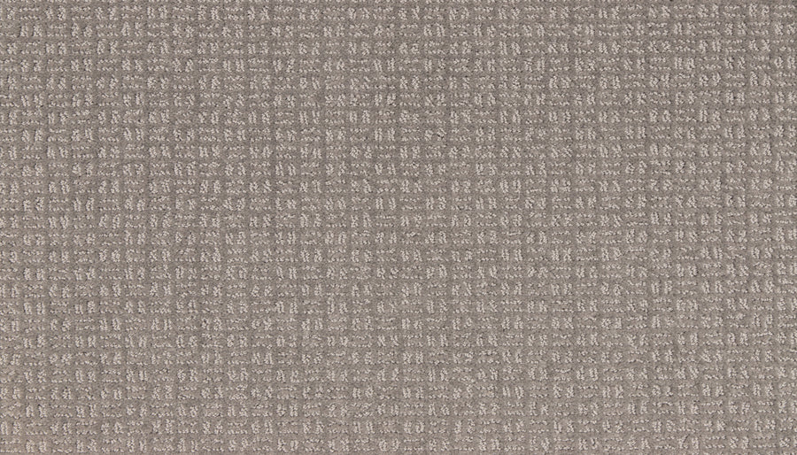 A close-up of Radiant Space On Trend Carpet in Rough Stone, showcasing a cushioned surface with a soft taupe hue and a subtle grid pattern of small, evenly spaced lines for modern appeal.