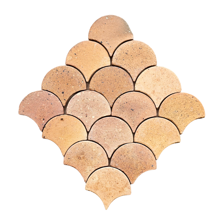 Tan, fan-shaped tiles in a symmetrical, overlapping design on a white background capture the artisanal warmth and earthy charm of Atelier Clay Scale Mosaic Natural Stone.