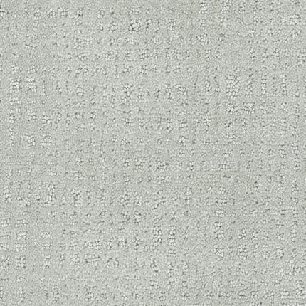 Homage Berber Carpet in Reflection features light gray textured fabric with a subtle, irregular geometric pattern of small raised rectangles and lines, offering a soft, muted look ideal for high-traffic areas.