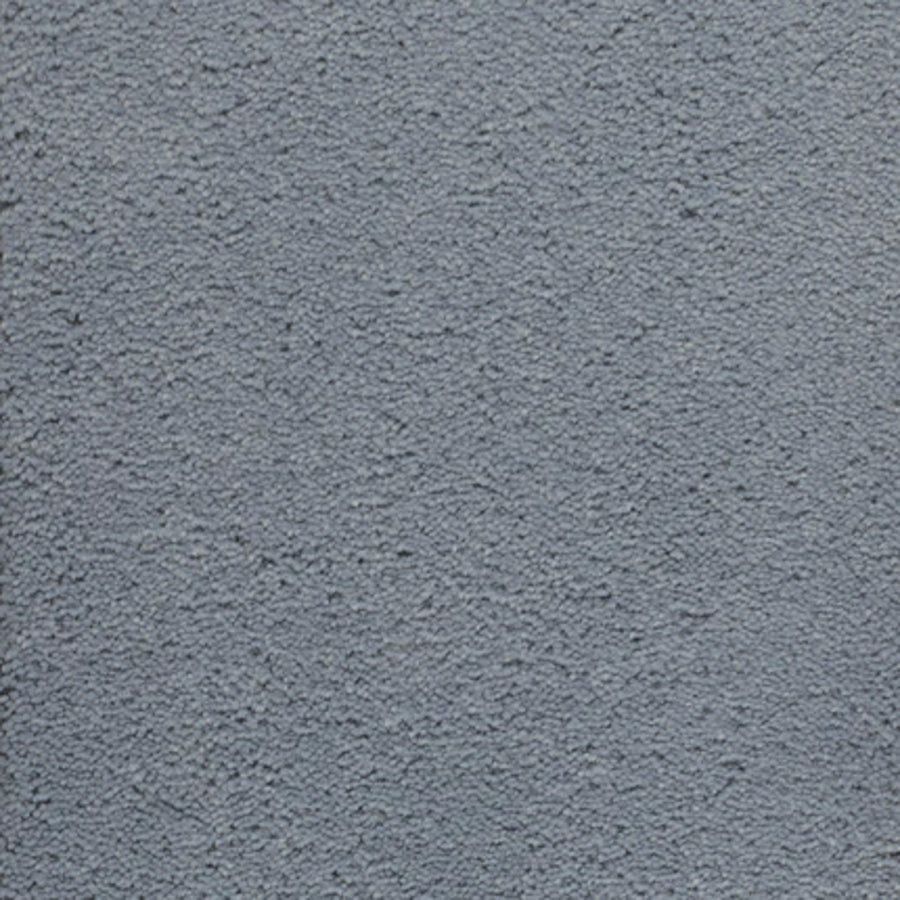 A close-up of Dolce Family Friendly Carpet in Regal-Blue reveals a textured surface with small bumps and a slightly rough, durable finish—perfect for high-traffic spaces that need both style and resilience.