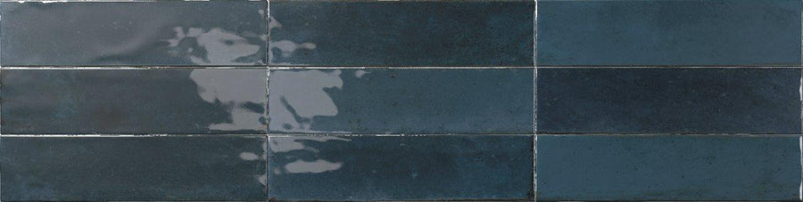 Six glossy dark blue Relic 2.7 x 11 Porcelain Tiles, featuring slight shade variation and reflective patches, arranged in two rows of three tiles each.