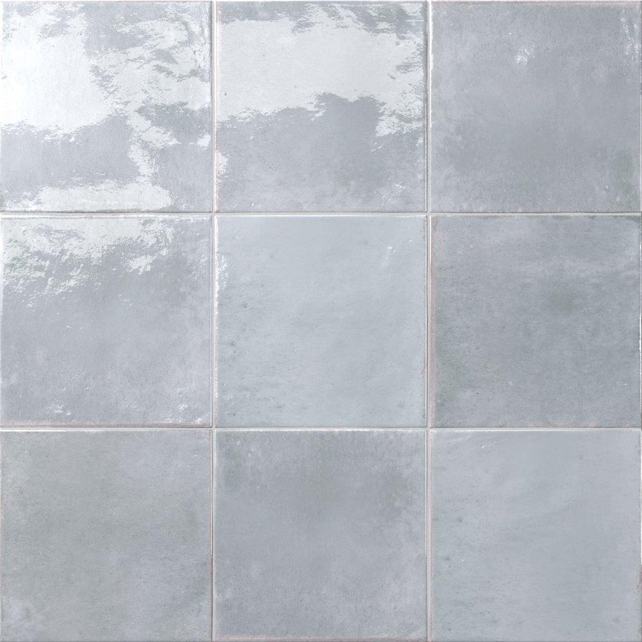 Nine Relic 5.8 x 5.8 Porcelain Tiles in light gray arranged in a 3x3 grid, each with a glossy, subtly reflective finish and slight variations in tone and texture.