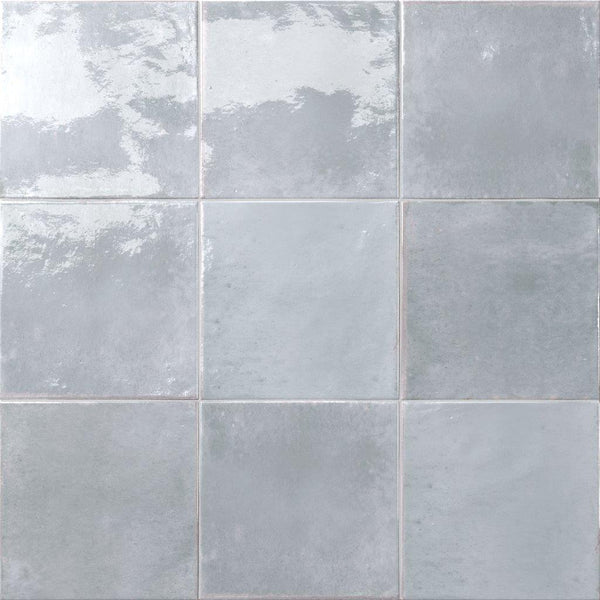 Nine Relic 5.8 x 5.8 Porcelain Tiles in light gray arranged in a 3x3 grid, each with a glossy, subtly reflective finish and slight variations in tone and texture.