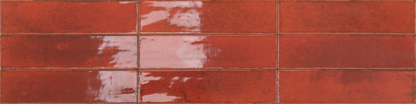 Relic 2.7 x 11 Porcelain Tiles, glossy and rectangular in red, are arranged in three horizontal rows, reflecting light at the center while showcasing subtle imperfections and natural shade variation throughout the surface.