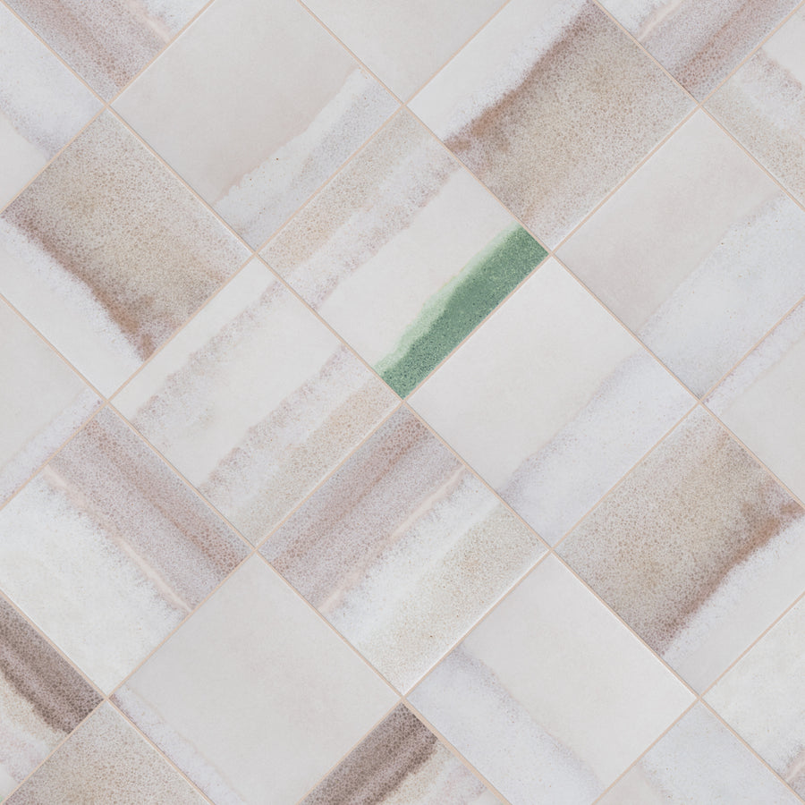 A grid of square tiles with soft beige and brown wavy patterns; one tile stands out with a distinct green stripe running through its center.
