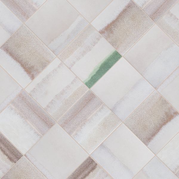A grid of square tiles with soft beige and brown wavy patterns; one tile stands out with a distinct green stripe running through its center.
