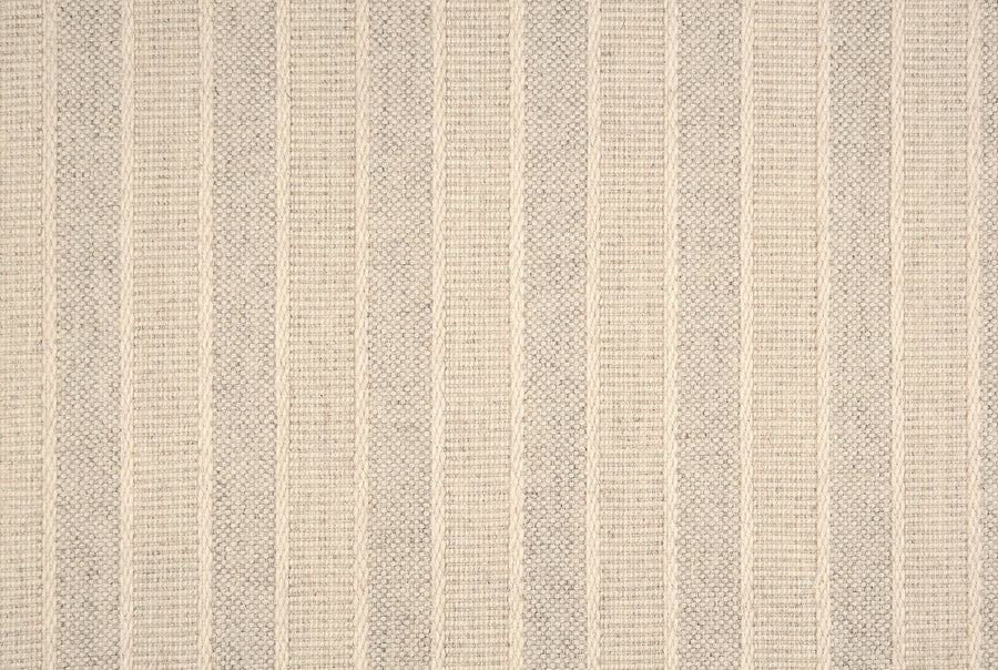 A close-up of the Renegade Stripe On Trend Carpet reveals a textured, ribbed surface featuring alternating beige and light grey vertical stripes for a subtle, contemporary neutral look.