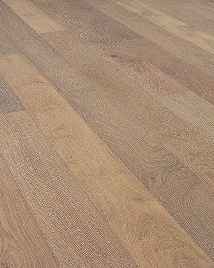 Close-up of Riverside European Oak 7" Hardwood flooring, highlighting smooth matte surface, varied grain patterns, and light to medium brown tones. Boards are laid lengthwise for a refined, natural look.