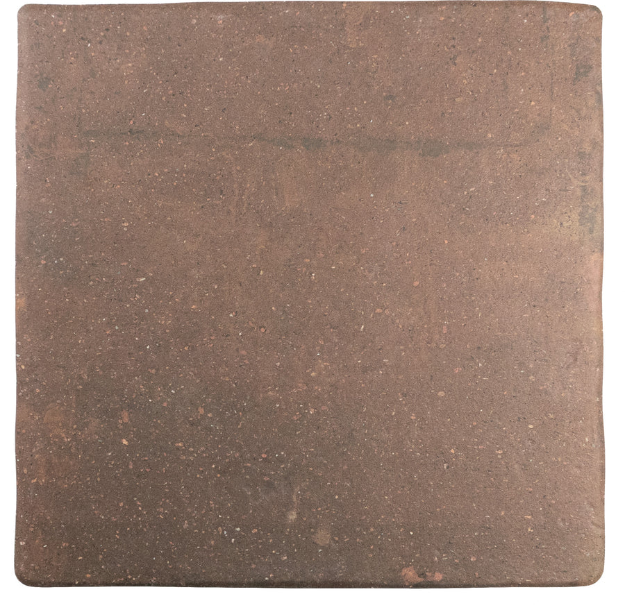 A single square, rust-colored Roots Large 8x6" x 8.6" Ceramic Tile with a rustic, slightly speckled surface and uneven edges, reminiscent of vintage design, photographed on a white background.