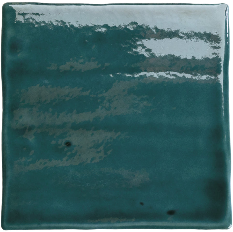 The Roots Small 4.3" x 4.3" Ceramic Tile in Teal Gloss features a glossy, square finish with deep teal tones and subtle shading, plus a reflective, slightly uneven surface—ideal for bold statement floors.