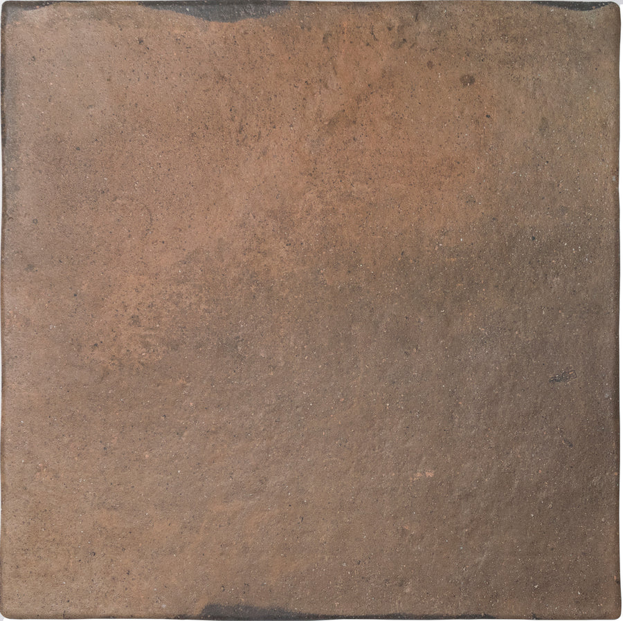 The Roots XXL 17.2" x 17.2" Ceramic Tile in Rust features a rough, textured surface with natural brown and reddish tones and slightly uneven edges for rustic charm, offering a unique alternative to modern tiles.