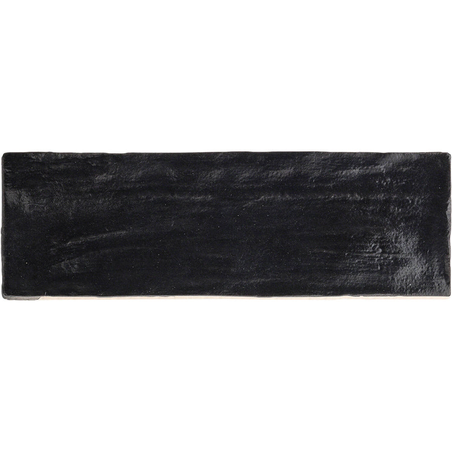 The Myorka 2" x 8" Subway Tile in black features a rectangular, glossy finish and subtly uneven edges, ideal for a bold kitchen backsplash. Shown here against a white background.