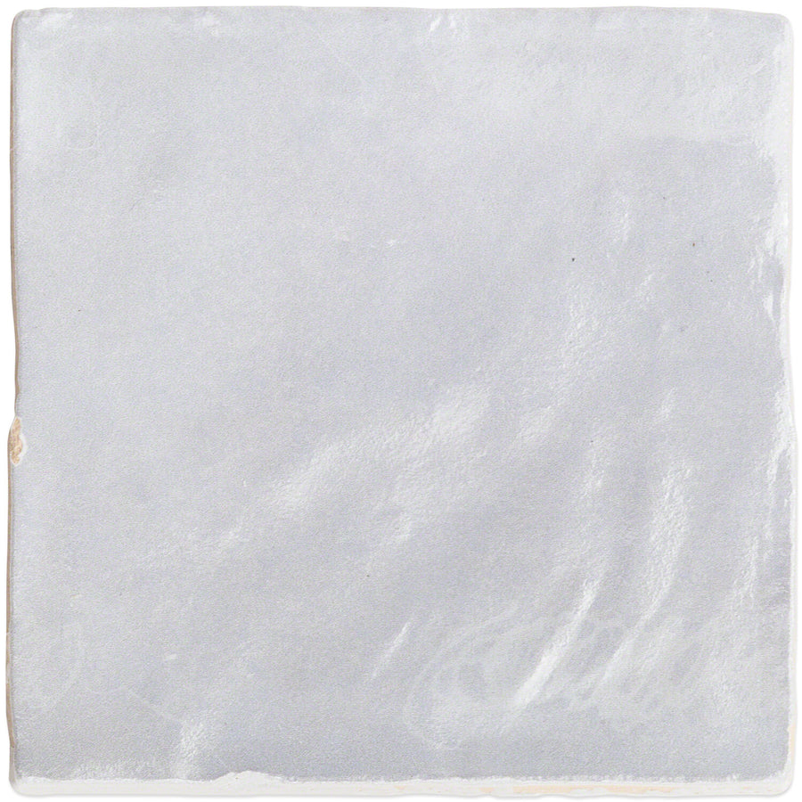 The Myorka 4" x 4" Ceramic Tile features a smooth, glossy grey surface and slightly uneven edges, making it perfect for creating a stylish kitchen backsplash.