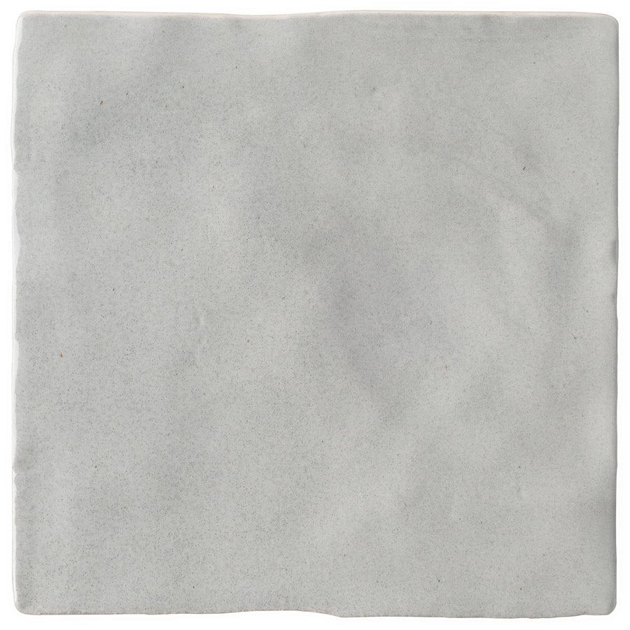 The Serena 4" x 4" Ceramic Tile in grey features a square shape, slightly uneven surface, and subtle texture. Its irregular edges create a handcrafted look, perfect for accent walls or modern backsplashes.