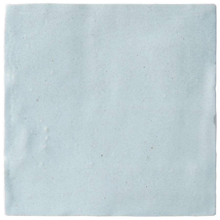 The Serena 4" x 4" Ceramic Tile in Sky features a light blue hue with a subtly uneven surface and gentle speckles, making it ideal for adding a handmade look to backsplashes or accent walls.