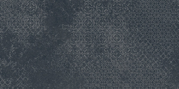 Shyft 12x24 Lace Deco features a dark textured surface with an intricate, repeating geometric and floral pattern in subtle lighter grey tones, reminiscent of vintage Brazilian slate for a look of faded elegance and ornate charm.