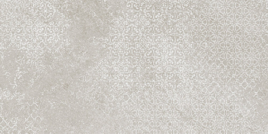 The Shyft 12x24 Lace Deco features an off-white and light gray textured background with delicate floral and geometric patterns, offering an elegant, vintage wallpaper effect inspired by refined rectified porcelain tile.