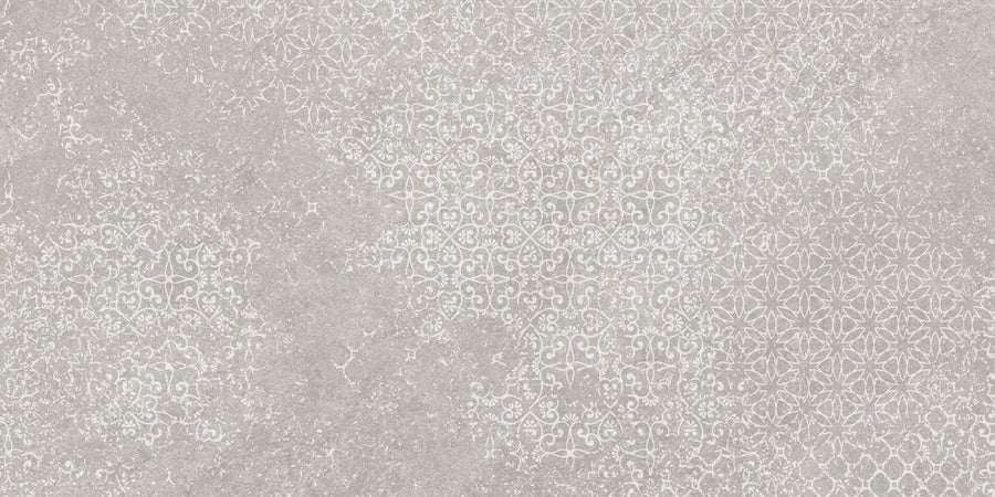Shyft 12x24 Lace Deco features a textured surface with a subtle, ornate white floral and geometric pattern on light gray, delivering a vintage, decorative look inspired by Brazilian slate in rectified porcelain.