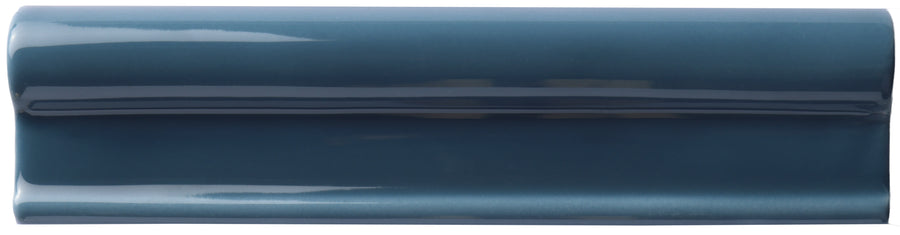 The Zephyr 2x8 Rail Molding Ceramic Tile features a glossy, dark blue Mediterranean finish with a raised, rounded center and smooth surface, offering handcrafted luxury in a sleek rectangular shape viewed from above on a white background.