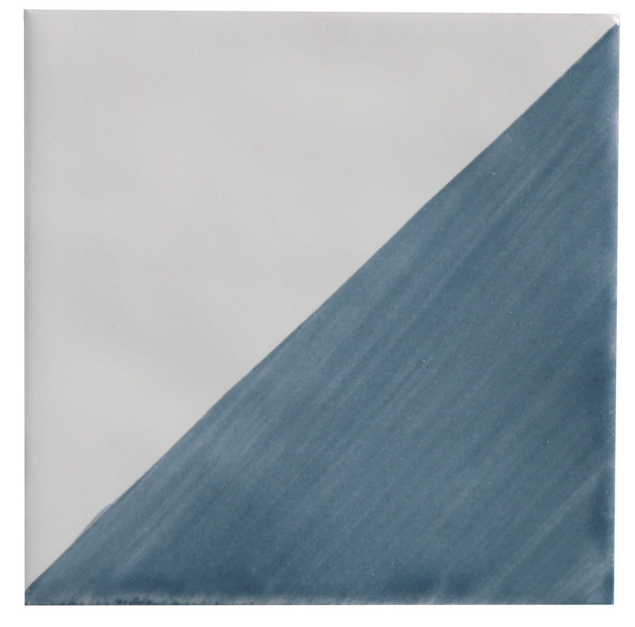 The Zephyr 4x4 Compass Deco Ceramic Tile features a diagonal design with a white upper left and textured blue-gray lower right, adding handcrafted luxury to any Mediterranean tile collection.