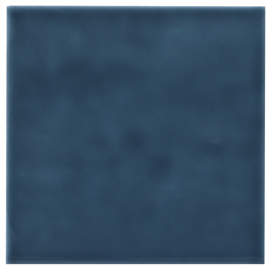 The Zephyr 4x4 Ceramic Tile is a single square ceramic tile with a smooth, glossy dark blue finish and subtle uneven shading—ideal for adding a Mediterranean touch; available as a special order.