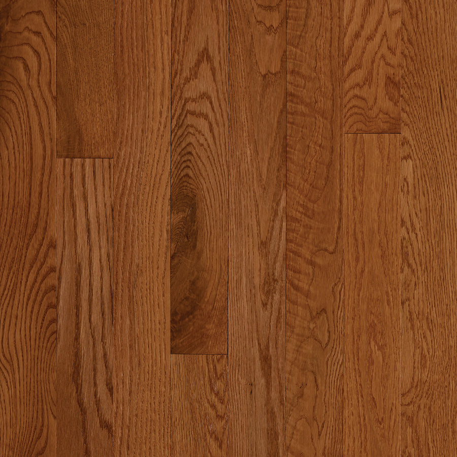 Close-up of St. Vincent 3 1/4" Hardwood in Red Oak Gunstock, showcasing polished reddish-brown floorboards with distinct vertical wood grain patterns.