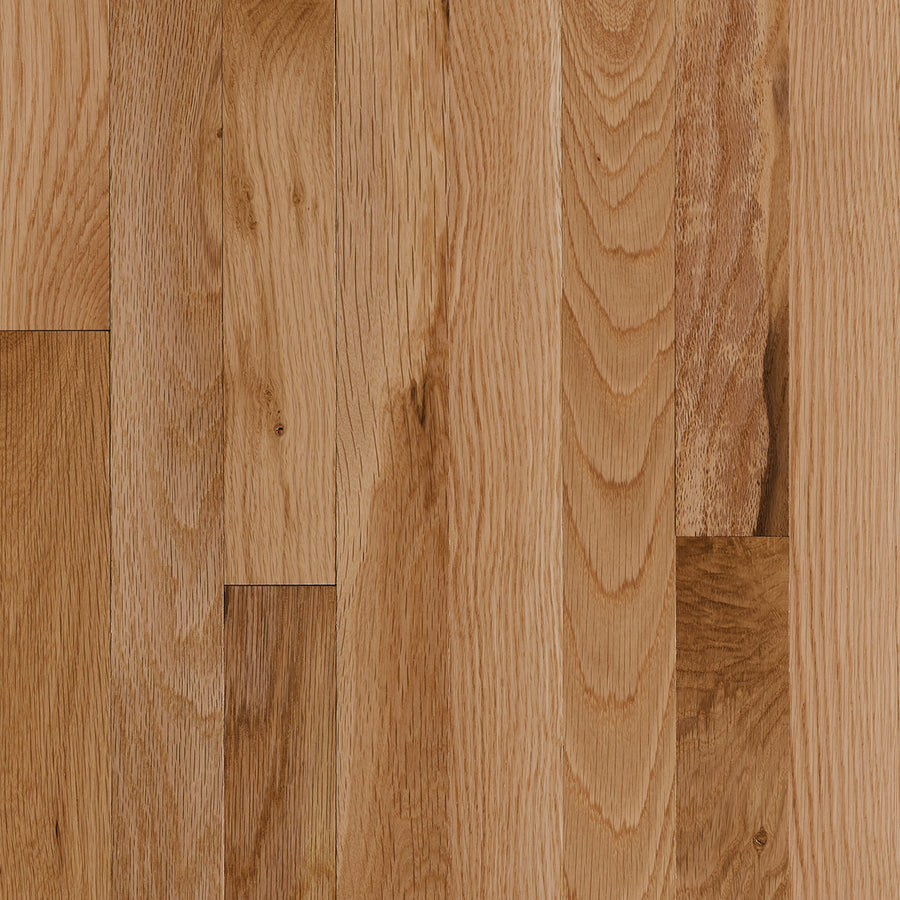 Close-up of St. Vincent 3 1/4" Hardwood in Red Oak Natural, featuring light brown planks with visible wood grain and textures, neatly arranged in a staggered pattern.