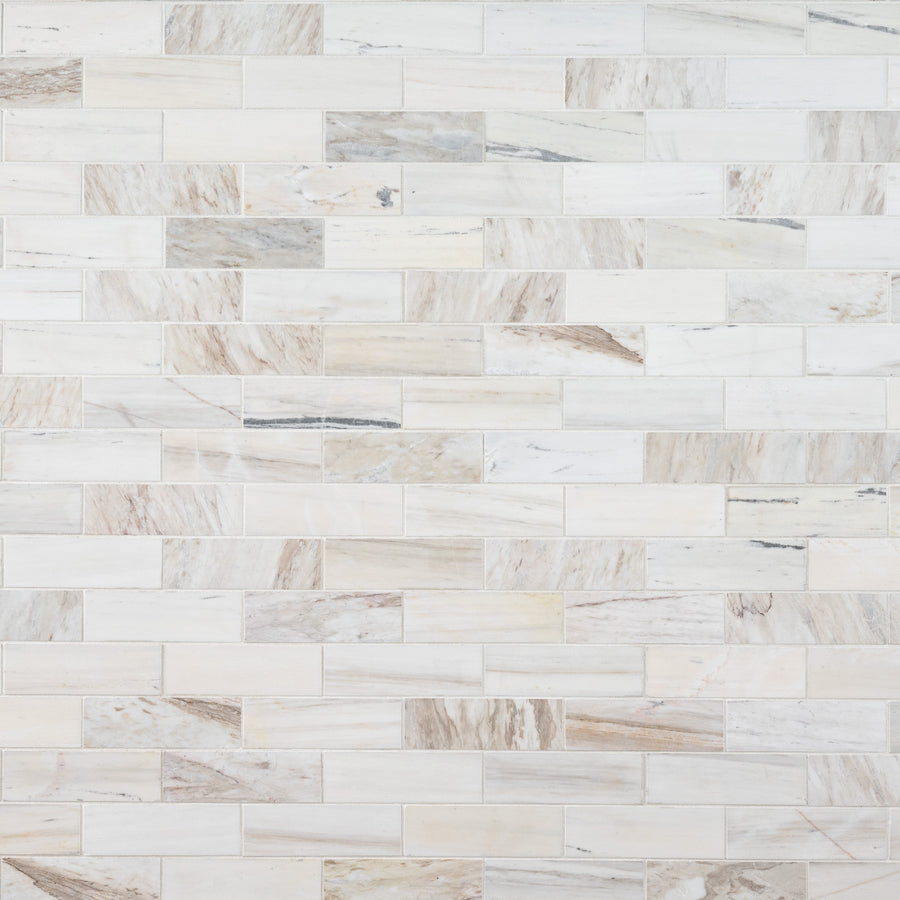 A wall adorned with Angora 2" x 6" Subway Mosaic in Polish, showcasing light beige and gray veining in a horizontal brick pattern—an elegant choice for kitchen backsplashes or bathroom walls.