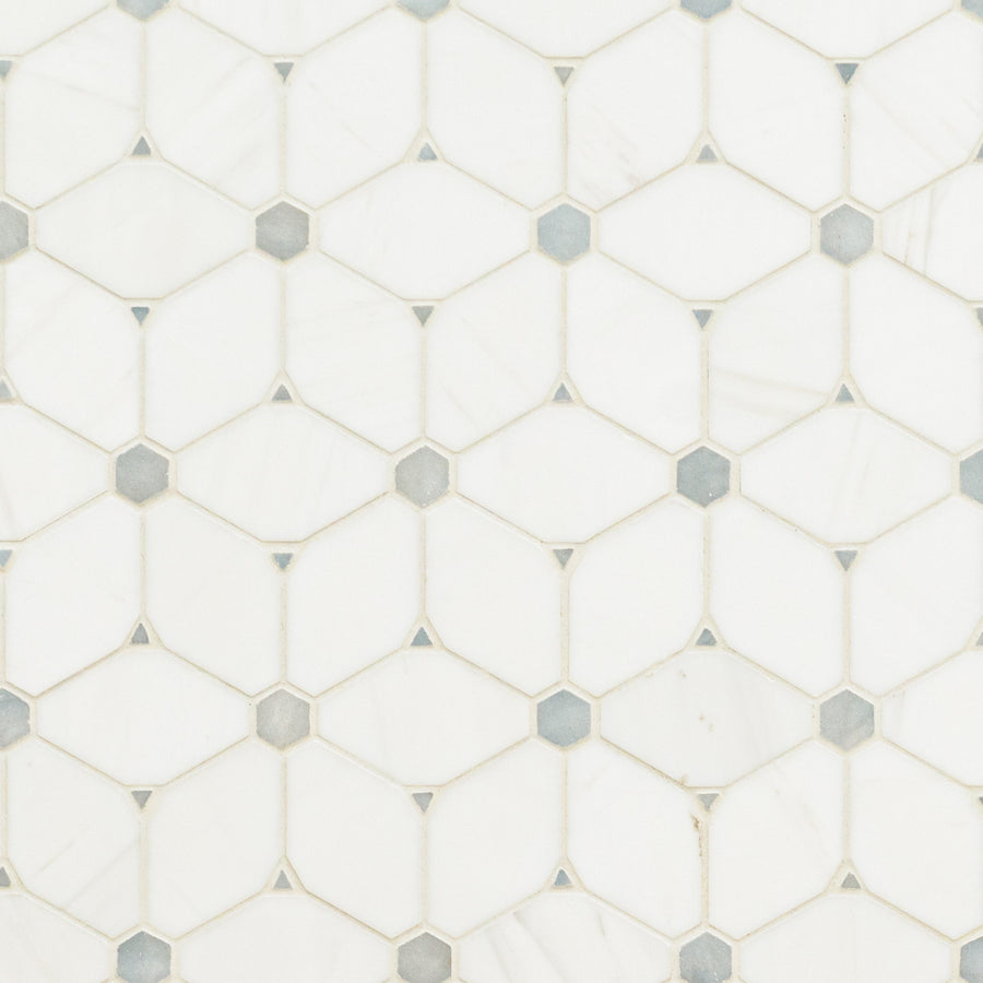 Stargaze Gray Polished Mosaic features white hexagonal tiles with small gray diamond-shaped inserts, forming a geometric pattern. Its smooth, glossy surface and subtle color variations offer a refined look in Stargaze Gray Polished.