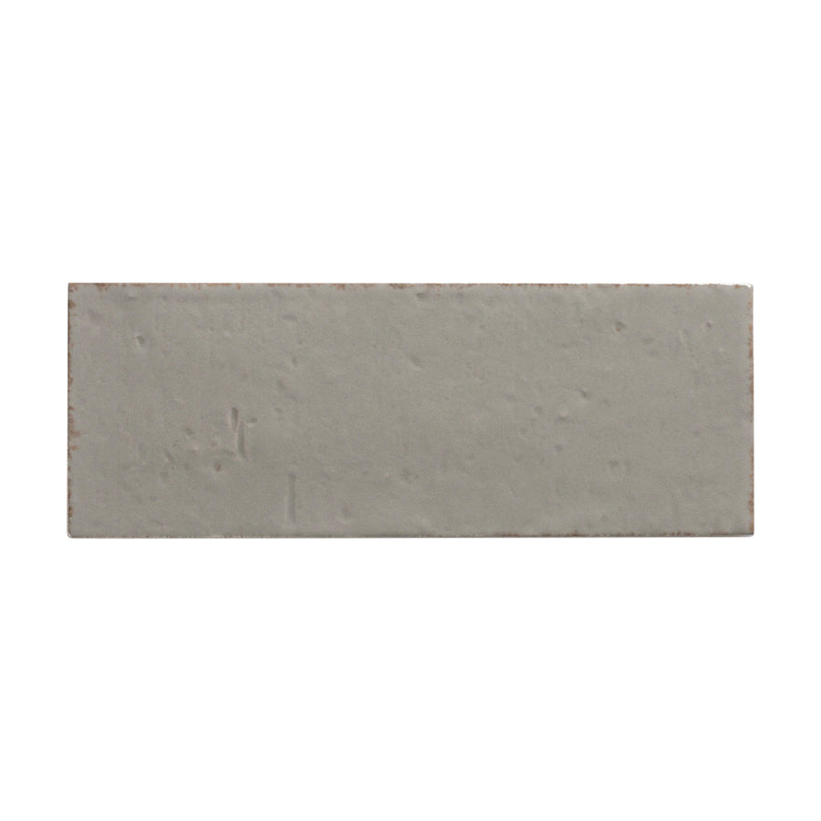 The Sarmento 3" x 8" Subway Porcelain Tile in Triolle features a rectangular, light gray design with a smooth, subtly textured surface and gentle imperfections, all crafted from premium porcelain.