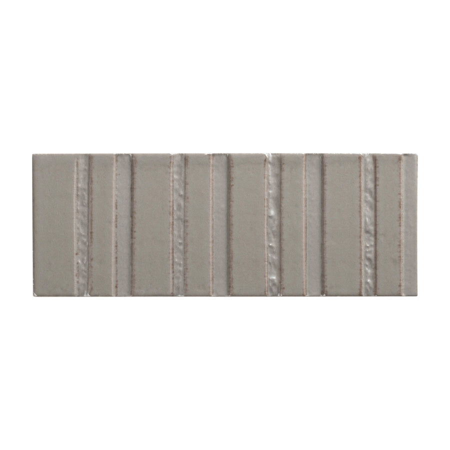 The Sarmento 3" x 8" Deco Subway Porcelain Tile in Triolle features vertical raised ridges and a linear textured stripe design, combining durable porcelain construction with modern style.