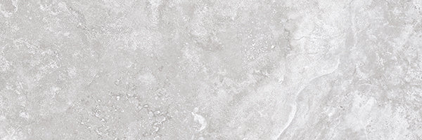 The Stream 4x12 Rectified Porcelain Tile features a light grey travertine look with subtle marbling and speckled patterns, creating a natural, smooth, and slightly weathered appearance.