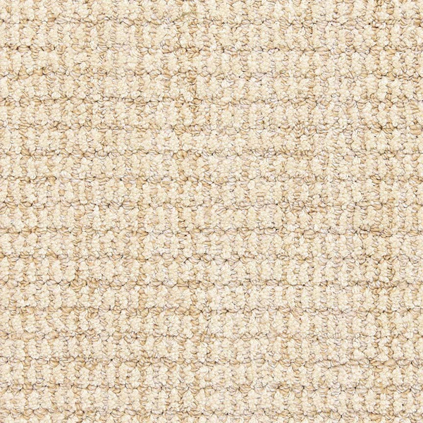 Close-up view of the Aspen Berber Carpet in Sand, featuring a looped, woven pattern. The soft, uniform surface has tightly packed fibers for durability and a subtle grid-like appearance.