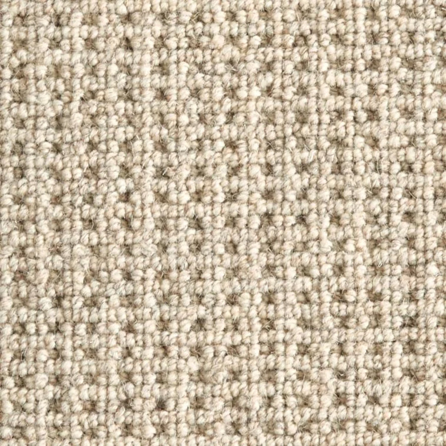 Close-up of Timbers Berber Carpet in Sandbar, featuring a looped pile and textured surface. Its tightly woven fibers create a soft, even feel with subtle neutral color variations—ideal for contemporary flooring.
