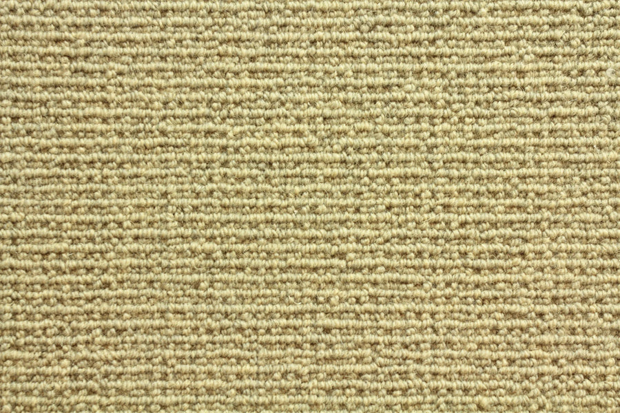 Close-up of Sequoia Berber Carpet in Sandstone—a light beige, tightly woven loop carpet made from premium materials, offering a textured look and lasting durability for high-traffic areas.