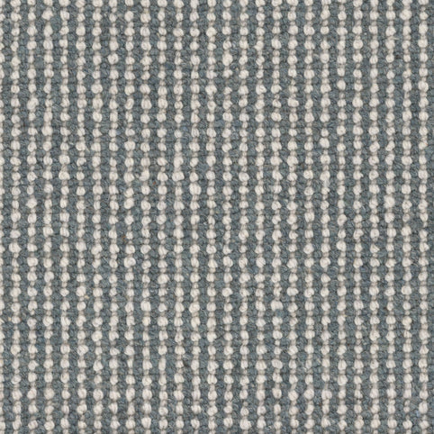 Close-up of the Andros Berber Carpet in Seaside, featuring a premium woven texture with vertical white and light grey lines forming dotted stripes on a muted blue-grey background.