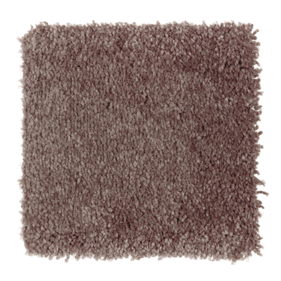 A square swatch of Sensible Style III Family Friendly Carpet in Flora—a textured, light brown, plush surface shown on a white background—offers soft comfort and suits modern spaces.