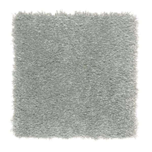 A square sample of Sensible Style III Family Friendly Carpet in Forgotten Statue showcases its light gray, plush, and textured look with a soft, fluffy feel, ideal for contemporary spaces, displayed on a white background.