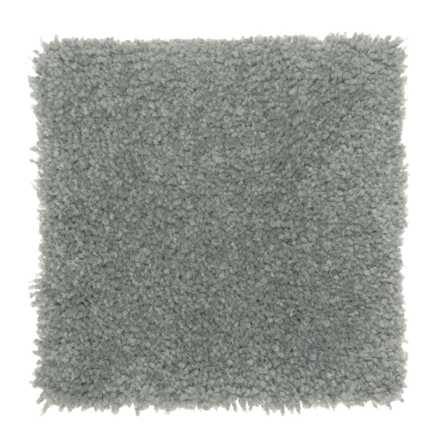 A square swatch of Sensible Style III Family Friendly Carpet in Hanging Garden, featuring light gray, plush texture and a soft, fluffy look with slightly uneven edges—ideal for adding comfort to modern spaces.