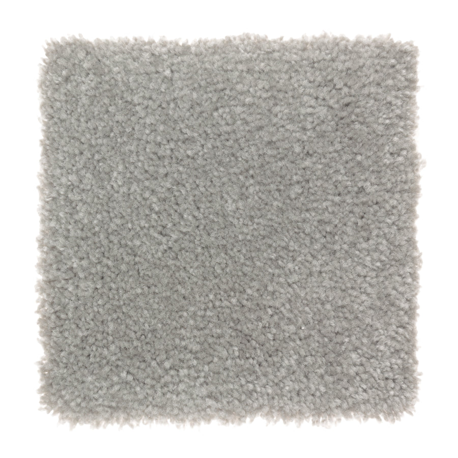 A square sample of Sensible Style III Family Friendly Carpet in Aspen Summitt—a light gray, plush, and dense textured carpet. Its slightly uneven edges highlight fluffy fibers, adding comfort and style to any modern space.