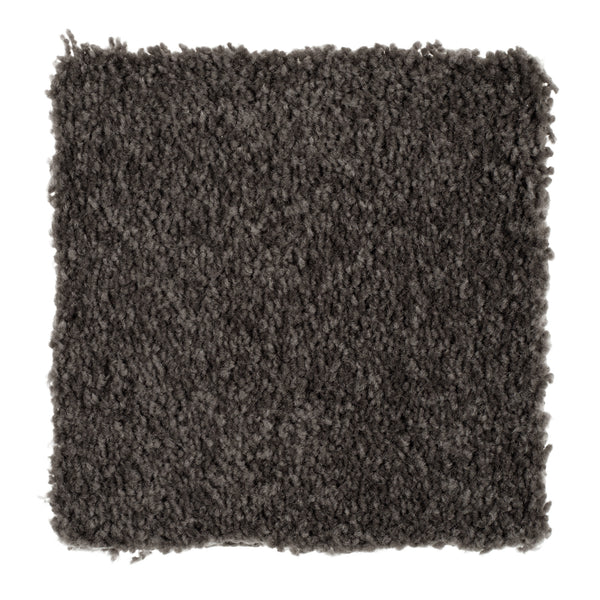 A close-up of Sensible Style III Family Friendly Carpet in Meteorite shows its dark gray, textured, plush surface—perfect for adding everyday comfort to any room.