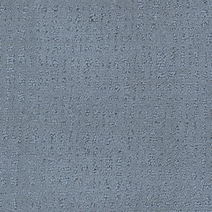 A close-up of Homage Berber Carpet in Seville shows its textured gray surface with an irregular dotted and dashed pattern—perfect for high-traffic areas.