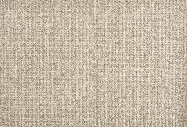 A close-up of Martina Berber Carpet in Shadow shows its beige, textured surface with a subtle woven pattern and grid-like threads—perfect for contemporary spaces needing soft, durable flooring for high-traffic areas. The surface is soft and slightly raised.