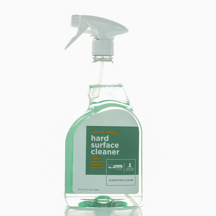 The Shaw Hard Surface 32OZ Spray Cleaner is a kid and pet-friendly green liquid in a clear spray bottle, ideal for floors, and helps support cleaning for a cause.