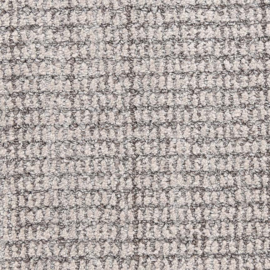 Close-up of Aspen Berber Carpet in Silver, featuring a soft, textured surface with a woven, grid-like pattern reminiscent of luxury carpeting.