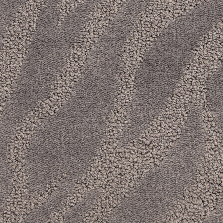 Close-up of Capetown On Trend Carpet in Silvermine, showcasing textured wavy lines in light and dark gray. Its soft, plush surface offers style and durability, making it ideal for high-traffic spaces.