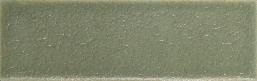 The Skin 1.6" x 5" Matte Subway Tile in Moss features a textured, uneven surface with muted green tones and subtle color variations, adding timeless elegance to any space.