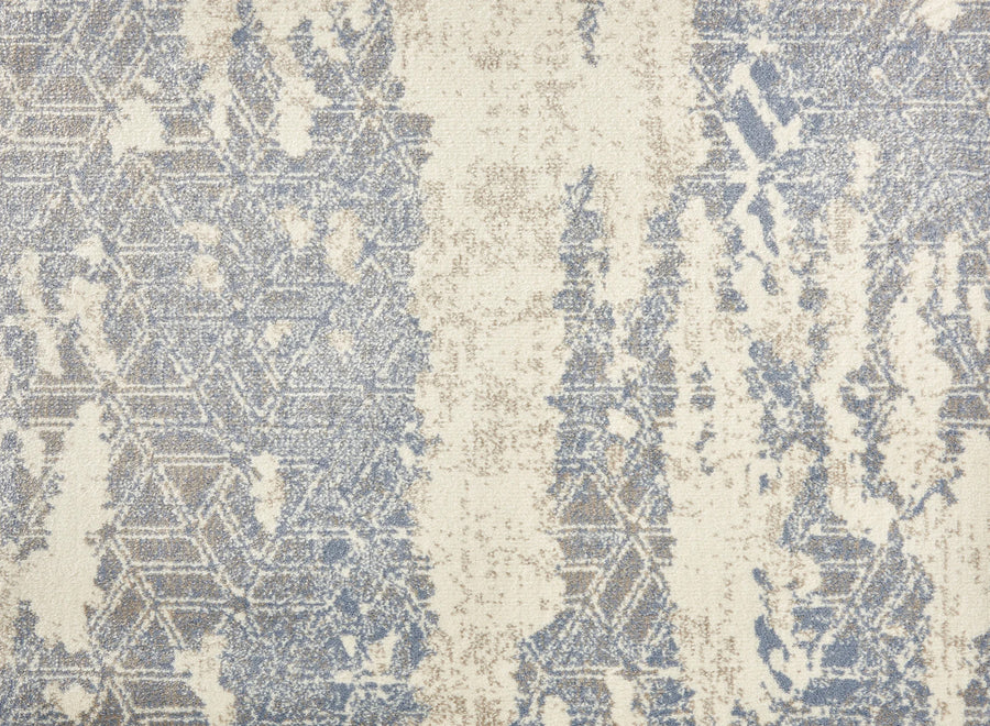 The Delphi On Trend Carpet in Sky features an abstract pattern with faded blue and beige geometric shapes on a textured cream background, evoking elegant flooring with the look of a weathered, distressed rug.
